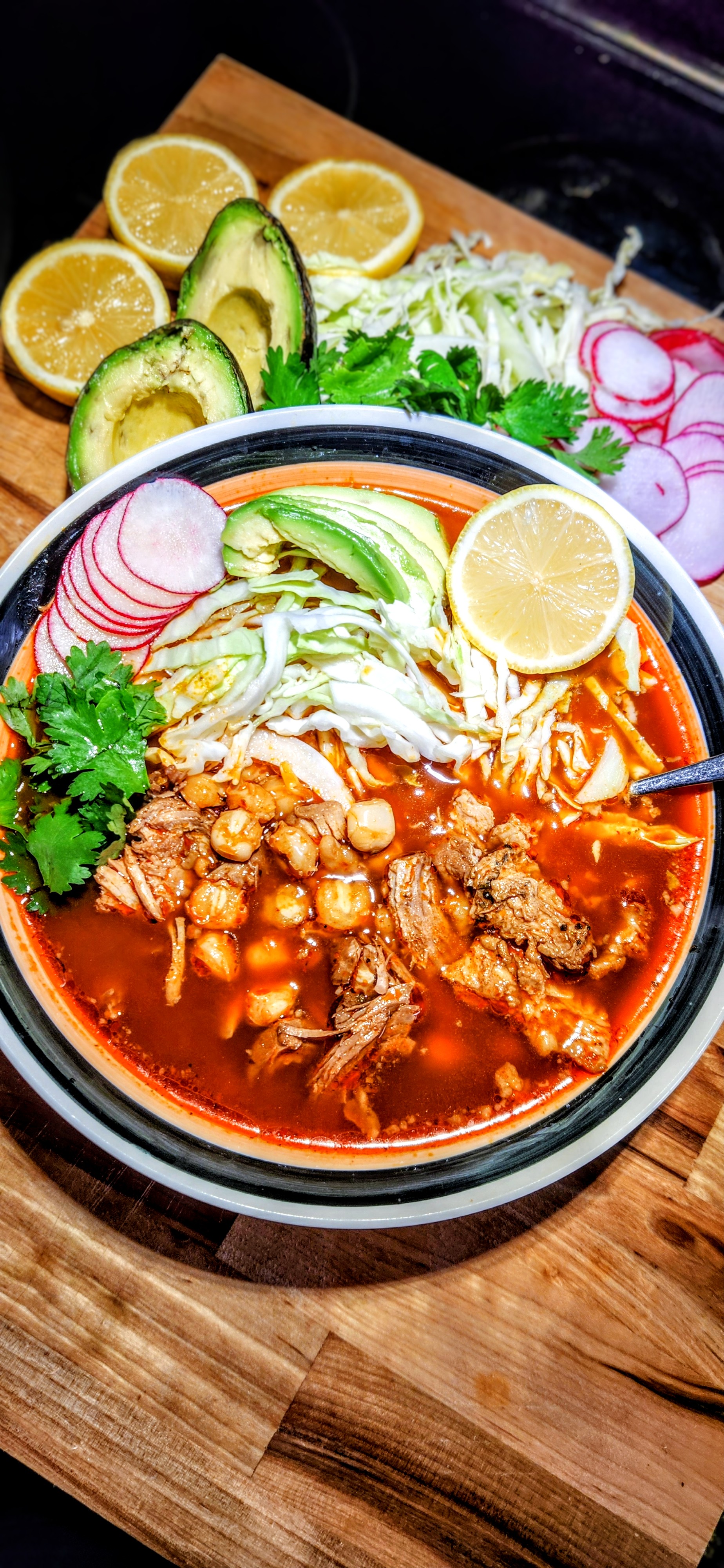 Pozole rojo with pork, hominy, avocado, radish, cabbage, and lime